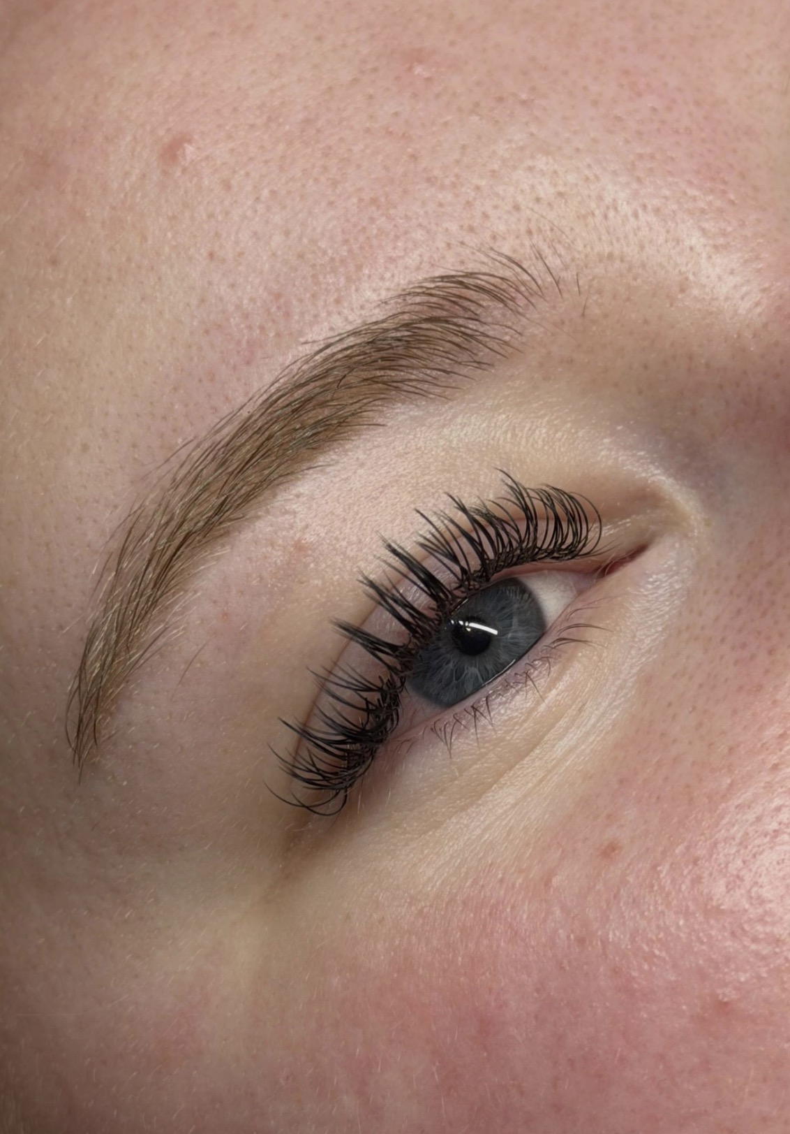 Close-up van volume wimperextensions en een geverfde, geshapete wenkbrauw